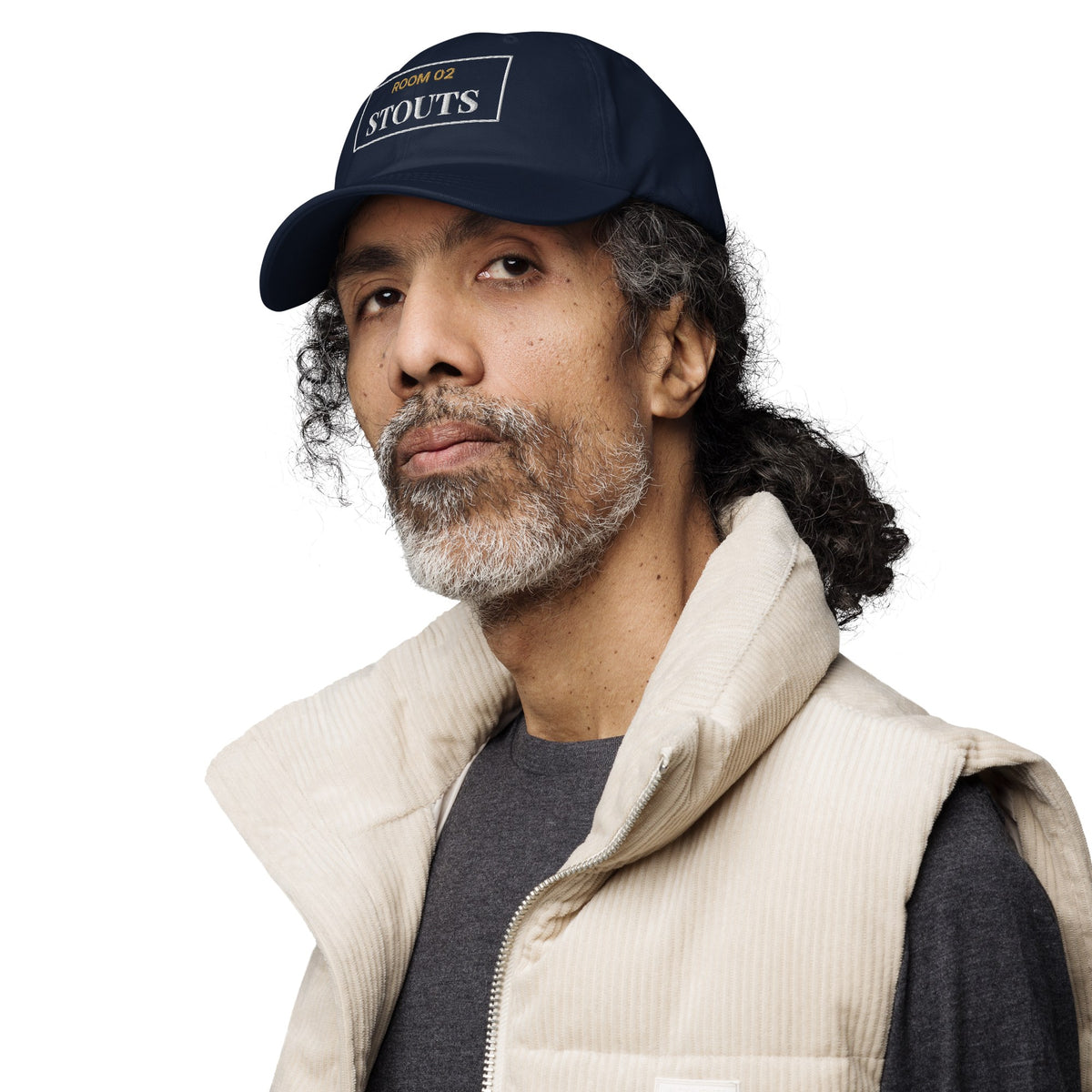 A man wearing the navy Room 02 Stouts cap